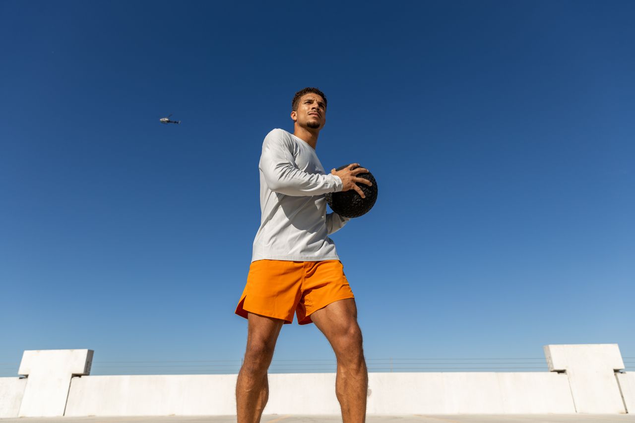 Man exercising with medicine ball on rooftop in Austin, Texas.